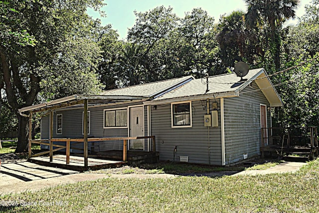 2508 Palmetto Dr, Cocoa, FL 32926 - view of front facade featuring a wooden deck, a front lawn, and roof with shingles