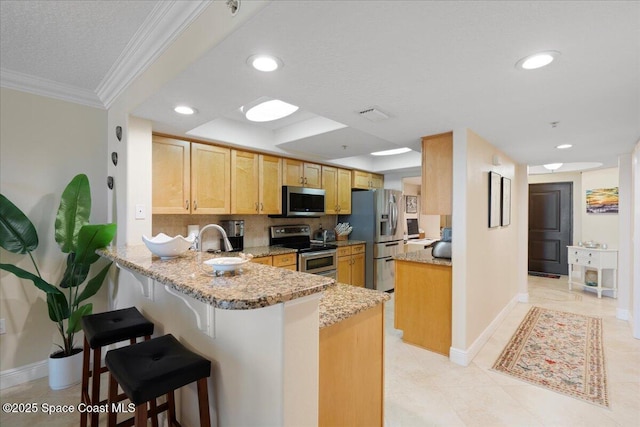 2375 S Atlantic Ave Unit 302, Cocoa Beach, FL 32931 - kitchen with appliances with stainless steel finishes, a peninsula, ornamental molding, a breakfast bar area, and light stone countertops