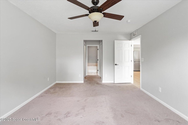 781 Dinner St NE, Palm Bay, FL 32907 - unfurnished bedroom featuring freestanding refrigerator, carpet floors, ensuite bathroom, and ceiling fan