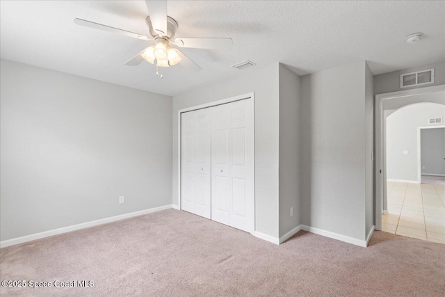 781 Dinner St NE, Palm Bay, FL 32907 - unfurnished bedroom with arched walkways, carpet, a closet, and a ceiling fan