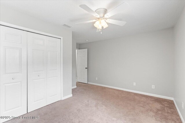 781 Dinner St NE, Palm Bay, FL 32907 - unfurnished bedroom with carpet, a closet, and a ceiling fan