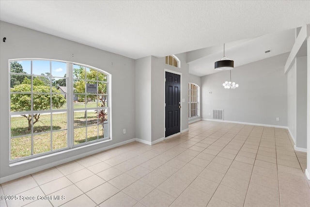 781 Dinner St NE, Palm Bay, FL 32907 - empty room featuring a chandelier, light tile patterned flooring, a textured ceiling, and vaulted ceiling