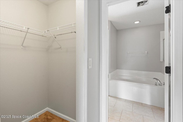781 Dinner St NE, Palm Bay, FL 32907 - full bathroom with a bath, a walk in closet, and tile patterned flooring