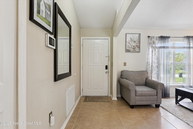 149 Hawthorne Ln NE, Palm Bay, FL 32907 - entrance foyer with a textured ceiling and light tile patterned flooring