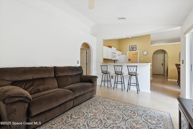 149 Hawthorne Ln NE, Palm Bay, FL 32907 - living room with arched walkways, light tile patterned floors, and high vaulted ceiling