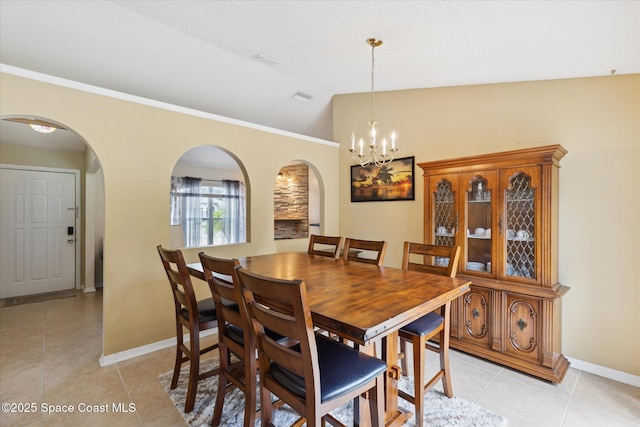 149 Hawthorne Ln NE, Palm Bay, FL 32907 - dining area with arched walkways, light tile patterned flooring, lofted ceiling, and a chandelier