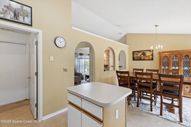 149 Hawthorne Ln NE, Palm Bay, FL 32907 - kitchen with arched walkways, light tile patterned flooring, lofted ceiling, a center island, and pendant lighting