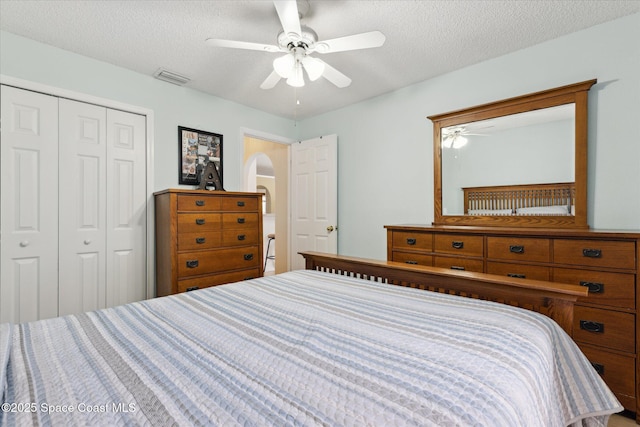 149 Hawthorne Ln NE, Palm Bay, FL 32907 - bedroom with a closet, a textured ceiling, arched walkways, and a ceiling fan