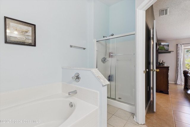 149 Hawthorne Ln NE, Palm Bay, FL 32907 - full bath with tile patterned flooring, a stall shower, a garden tub, and a textured ceiling