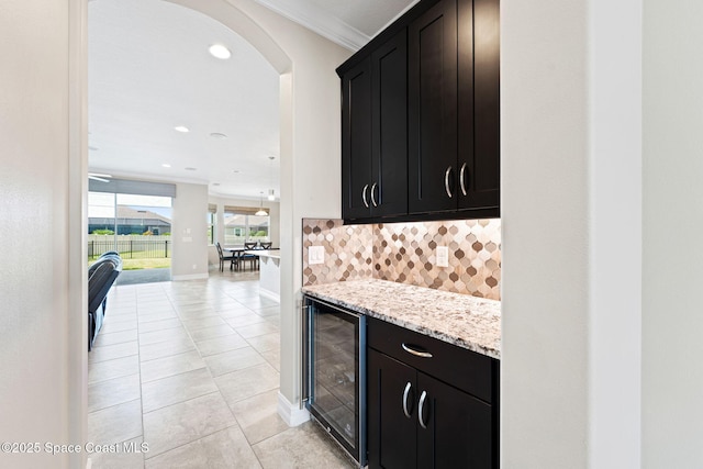 7684 Poulicny Ln, Melbourne, FL 32940 - bar with beverage cooler, tasteful backsplash, crown molding, light tile patterned floors, and recessed lighting