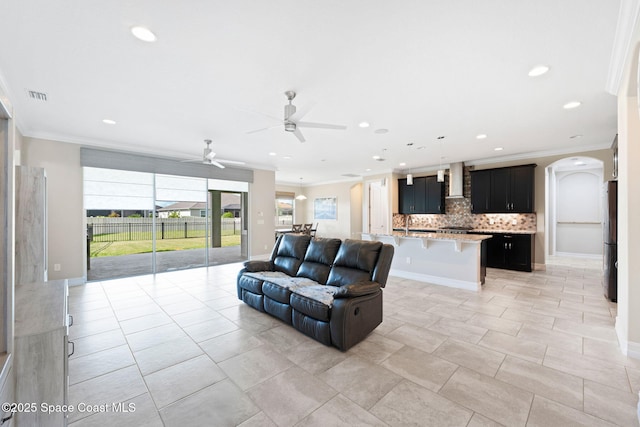 7684 Poulicny Ln, Melbourne, FL 32940 - living room featuring a ceiling fan, crown molding, arched walkways, and recessed lighting