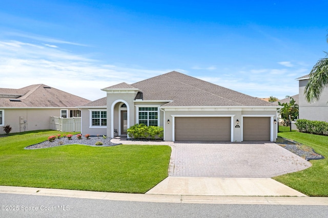 7684 Poulicny Ln, Melbourne, FL 32940 - view of front of property with a garage, decorative driveway, stucco siding, a front lawn, and roof with shingles