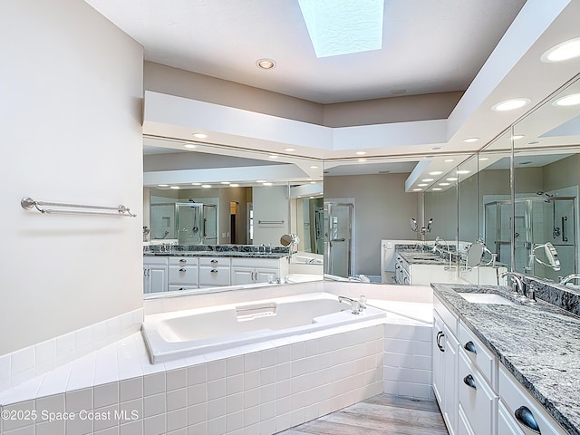 3090 Rio Pino S, Indialantic, FL 32903 - full bath featuring a stall shower, a garden tub, two vanities, wood finished floors, and recessed lighting