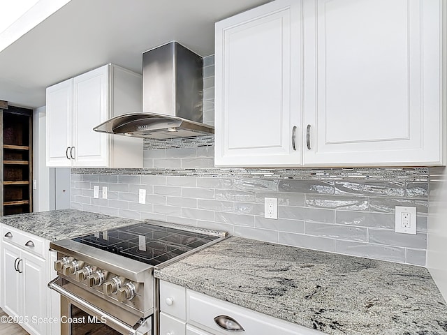 3090 Rio Pino S, Indialantic, FL 32903 - kitchen with wall chimney range hood, high end range, light stone counters, and white cabinetry