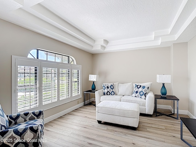 3090 Rio Pino S, Indialantic, FL 32903 - living room featuring a raised ceiling, a textured ceiling, healthy amount of natural light, and light wood-type flooring