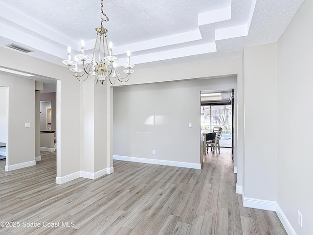 3090 Rio Pino S, Indialantic, FL 32903 - unfurnished room with a chandelier, a textured ceiling, and light wood finished floors