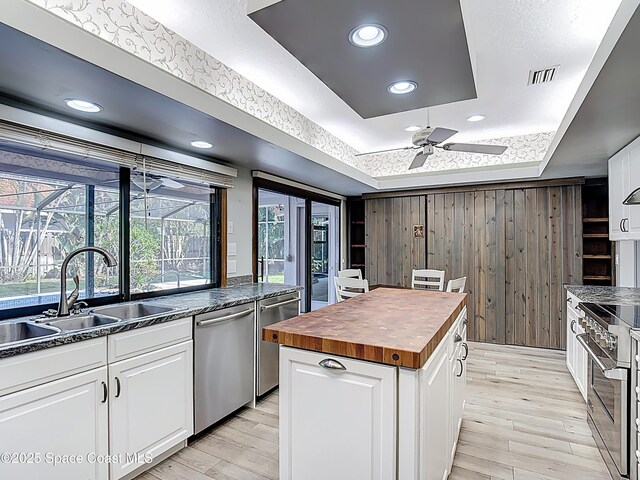 3090 Rio Pino S, Indialantic, FL 32903 - kitchen with wooden counters, appliances with stainless steel finishes, a raised ceiling, a ceiling fan, and light wood-style floors