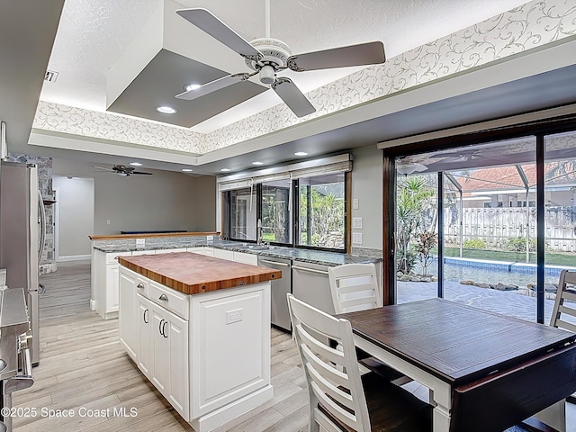 3090 Rio Pino S, Indialantic, FL 32903 - kitchen with butcher block counters, a ceiling fan, a raised ceiling, a kitchen island, and stainless steel appliances