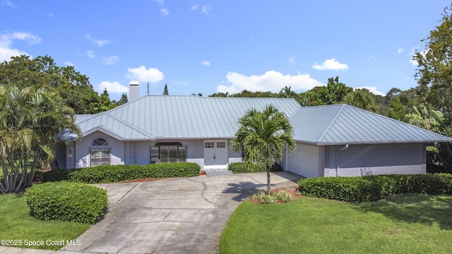 3090 Rio Pino S, Indialantic, FL 32903 - ranch-style home with a chimney, a garage, a metal roof, and stucco siding