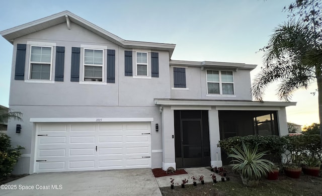 1015 Swiss Pointe Ln, Rockledge, FL 32955 - view of front of property with a garage, a sunroom, concrete driveway, and stucco siding
