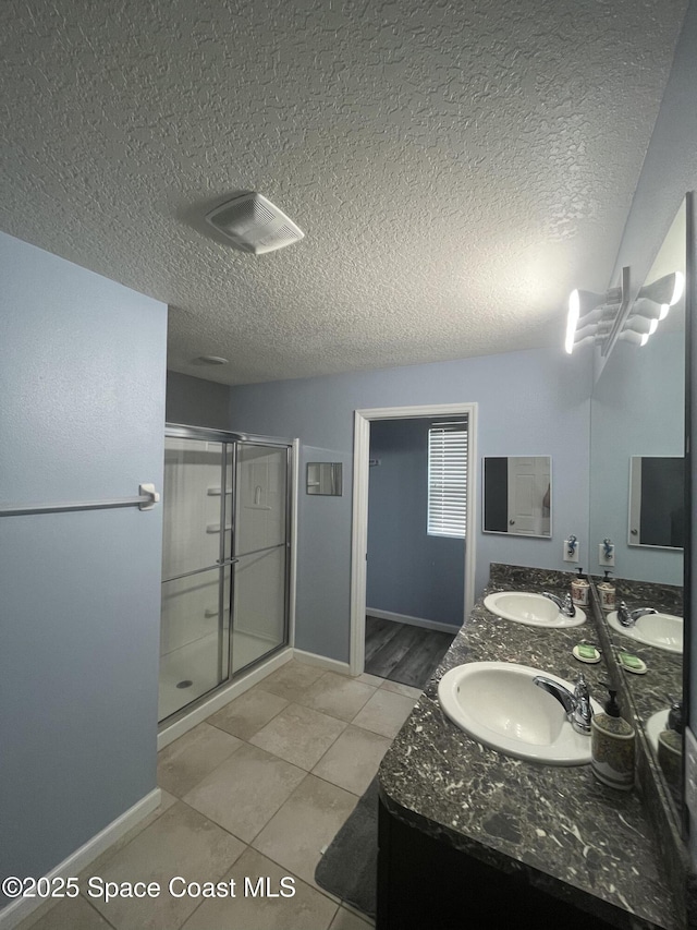 1015 Swiss Pointe Ln, Rockledge, FL 32955 - bathroom with a shower stall, double vanity, tile patterned flooring, and a textured ceiling