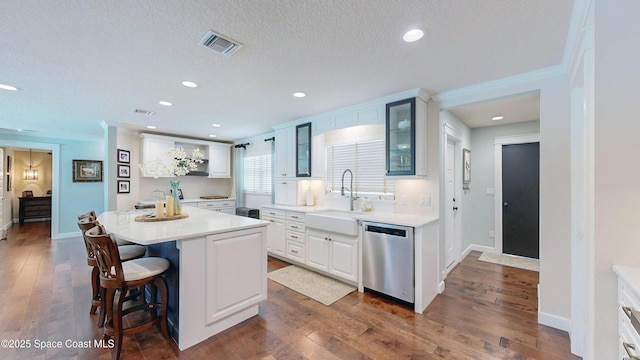 211 Jamaica Dr, Cocoa Beach, FL 32931 - kitchen with dishwasher, glass insert cabinets, a breakfast bar area, dark wood-style flooring, and recessed lighting