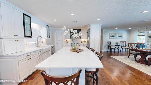 211 Jamaica Dr, Cocoa Beach, FL 32931 - kitchen featuring stainless steel dishwasher, a kitchen breakfast bar, white cabinetry, recessed lighting, and dark wood-type flooring