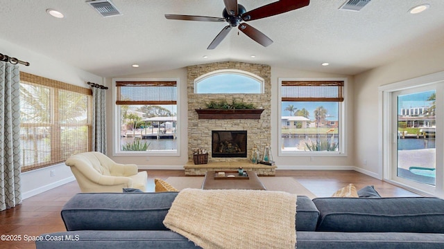 211 Jamaica Dr, Cocoa Beach, FL 32931 - living area with vaulted ceiling, a ceiling fan, a textured ceiling, recessed lighting, and a stone fireplace