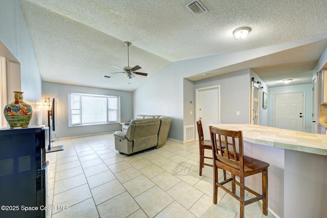 2169 Wagonwheel Ave SE, Palm Bay, FL 32909 - living area with a ceiling fan, a textured ceiling, lofted ceiling, and light tile patterned floors
