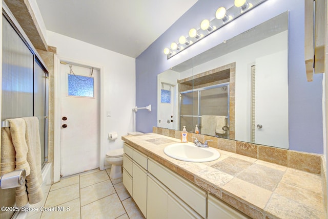 2169 Wagonwheel Ave SE, Palm Bay, FL 32909 - full bath featuring vanity, tile patterned floors, and bath / shower combo with glass door