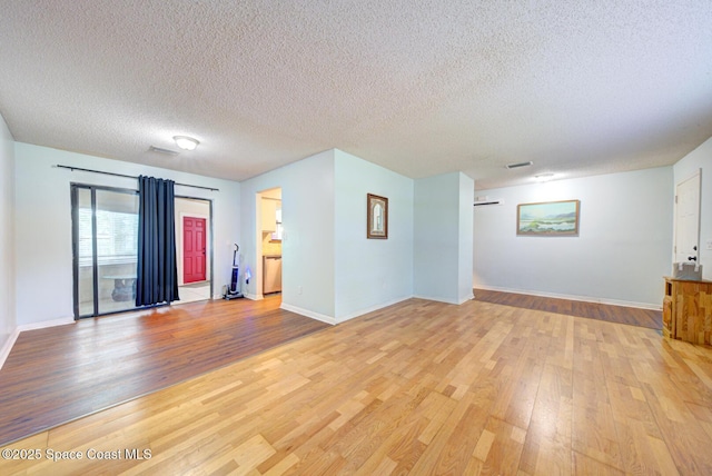 2169 Wagonwheel Ave SE, Palm Bay, FL 32909 - unfurnished living room featuring light wood-style flooring and a textured ceiling