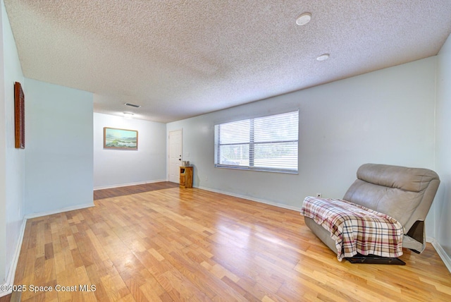 2169 Wagonwheel Ave SE, Palm Bay, FL 32909 - living area featuring light wood-style floors and a textured ceiling