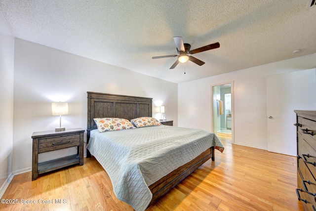 2169 Wagonwheel Ave SE, Palm Bay, FL 32909 - bedroom featuring light wood finished floors, ceiling fan, a textured ceiling, and connected bathroom