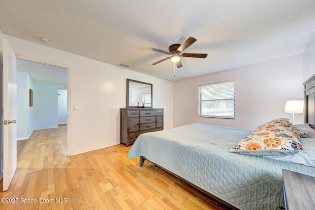 2169 Wagonwheel Ave SE, Palm Bay, FL 32909 - bedroom with light wood-style flooring, a ceiling fan, and a textured ceiling