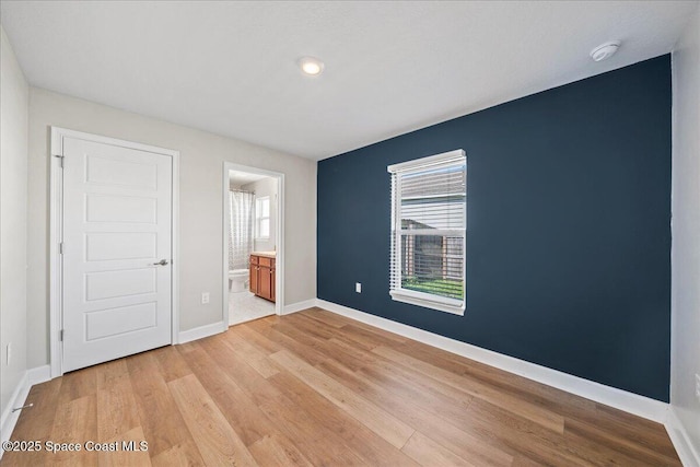 215 Olin Rd SW, Palm Bay, FL 32908 - unfurnished bedroom with light wood-style flooring, ensuite bathroom, and recessed lighting