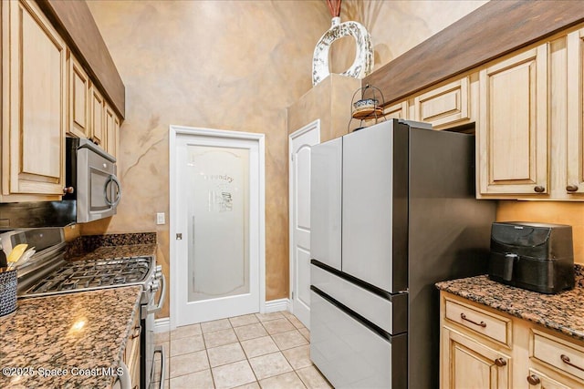 970 Pelican Ln, Rockledge, FL 32955 - kitchen featuring stainless steel appliances, light tile patterned floors, dark stone countertops, and light brown cabinetry