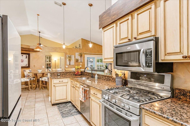970 Pelican Ln, Rockledge, FL 32955 - kitchen featuring appliances with stainless steel finishes, lofted ceiling, a peninsula, dark stone counters, and light tile patterned floors