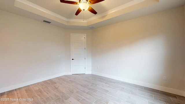 1507 Wichita Blvd SE, Palm Bay, FL 32909 - empty room featuring a tray ceiling, a ceiling fan, and light wood-type flooring
