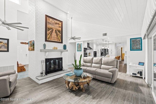 2945 Newfound Harbor Dr, Merritt Island, FL 32952 - living room with a ceiling fan, wood finished floors, a brick fireplace, high vaulted ceiling, and wooden ceiling