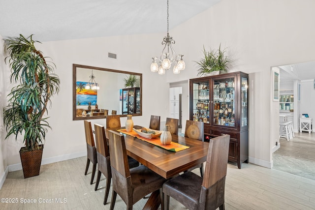 2945 Newfound Harbor Dr, Merritt Island, FL 32952 - dining room featuring vaulted ceiling, a chandelier, and light wood-style flooring