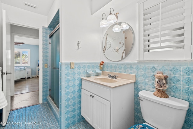 2945 Newfound Harbor Dr, Merritt Island, FL 32952 - full bathroom featuring a shower stall, vanity, tile patterned floors, a wainscoted wall, and tile walls