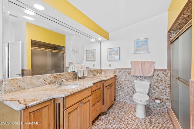 2945 Newfound Harbor Dr, Merritt Island, FL 32952 - full bathroom with tile walls, double vanity, a stall shower, tile patterned flooring, and a wainscoted wall