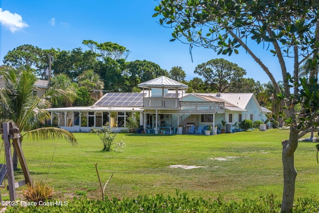 2945 Newfound Harbor Dr, Merritt Island, FL 32952 - rear view of property featuring solar panels, a lawn, a metal roof, stairs, and a wooden deck