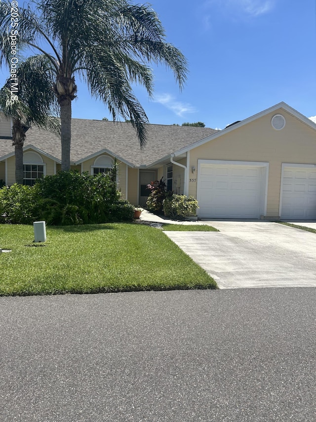 537 6th St, Vero Beach, FL 32962 - ranch-style house featuring a garage, a front yard, driveway, and roof with shingles