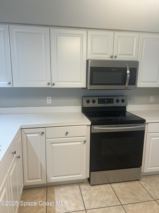 537 6th St, Vero Beach, FL 32962 - kitchen featuring stainless steel appliances, white cabinets, light tile patterned floors, and light countertops