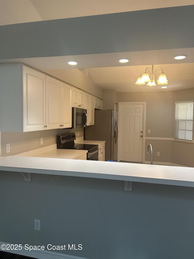 537 6th St, Vero Beach, FL 32962 - kitchen with stainless steel appliances, a kitchen bar, light countertops, recessed lighting, and white cabinetry