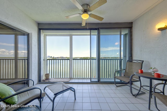 3609 S Banana River Blvd Unit C511, Cocoa Beach, FL 32931 - sunroom with a textured wall, a water view, a textured ceiling, and tile patterned flooring