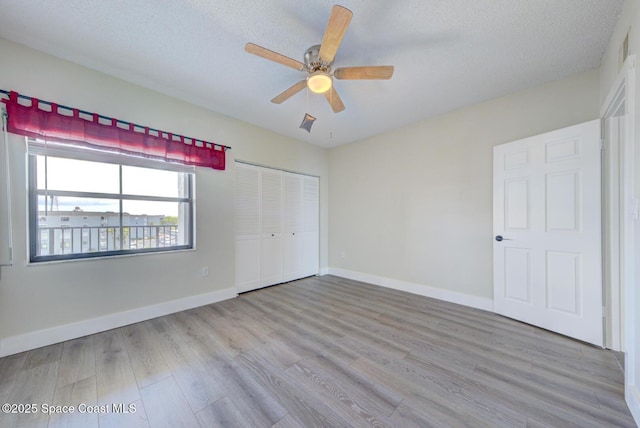 3609 S Banana River Blvd Unit C511, Cocoa Beach, FL 32931 - unfurnished bedroom featuring wood finished floors, a closet, a textured ceiling, and a ceiling fan