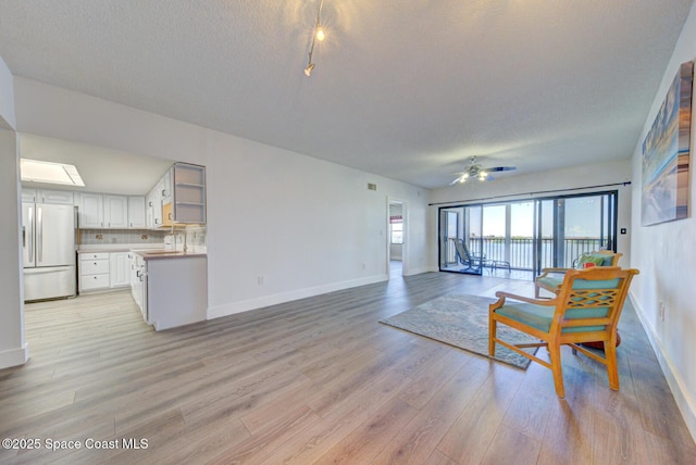3609 S Banana River Blvd Unit C511, Cocoa Beach, FL 32931 - unfurnished living room with light wood-style floors, a ceiling fan, and a textured ceiling