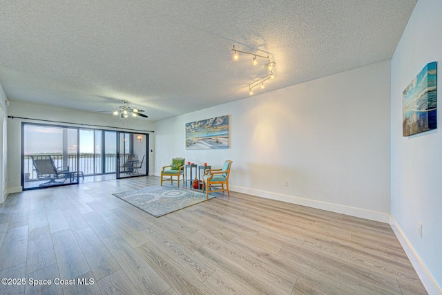 3609 S Banana River Blvd Unit C511, Cocoa Beach, FL 32931 - sitting room featuring a textured ceiling, light wood-style flooring, and ceiling fan